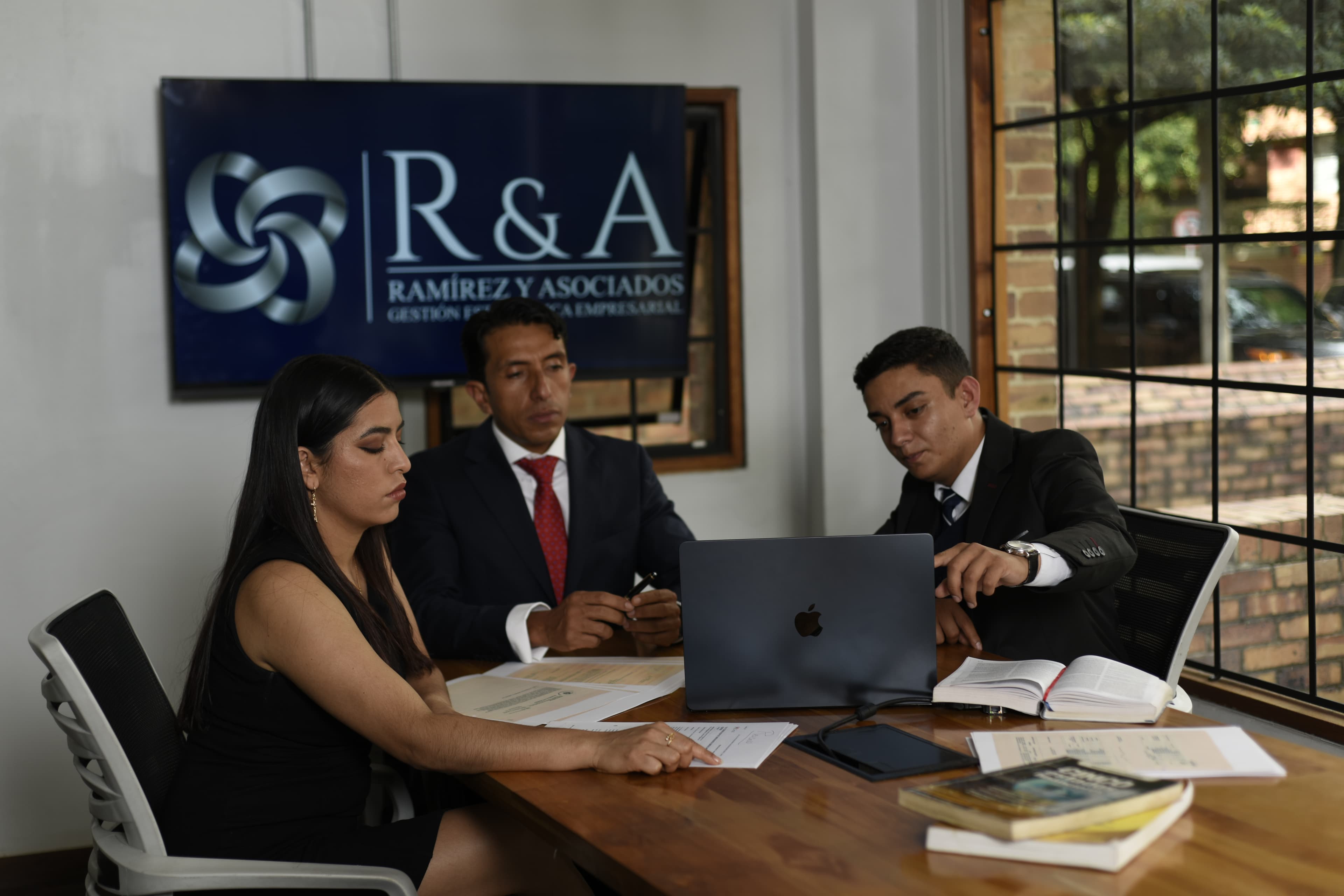 Equipo revisando documentos de trabajo en una reunión empresarial